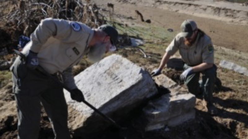 Two park rangers uncovering the stepping stones.