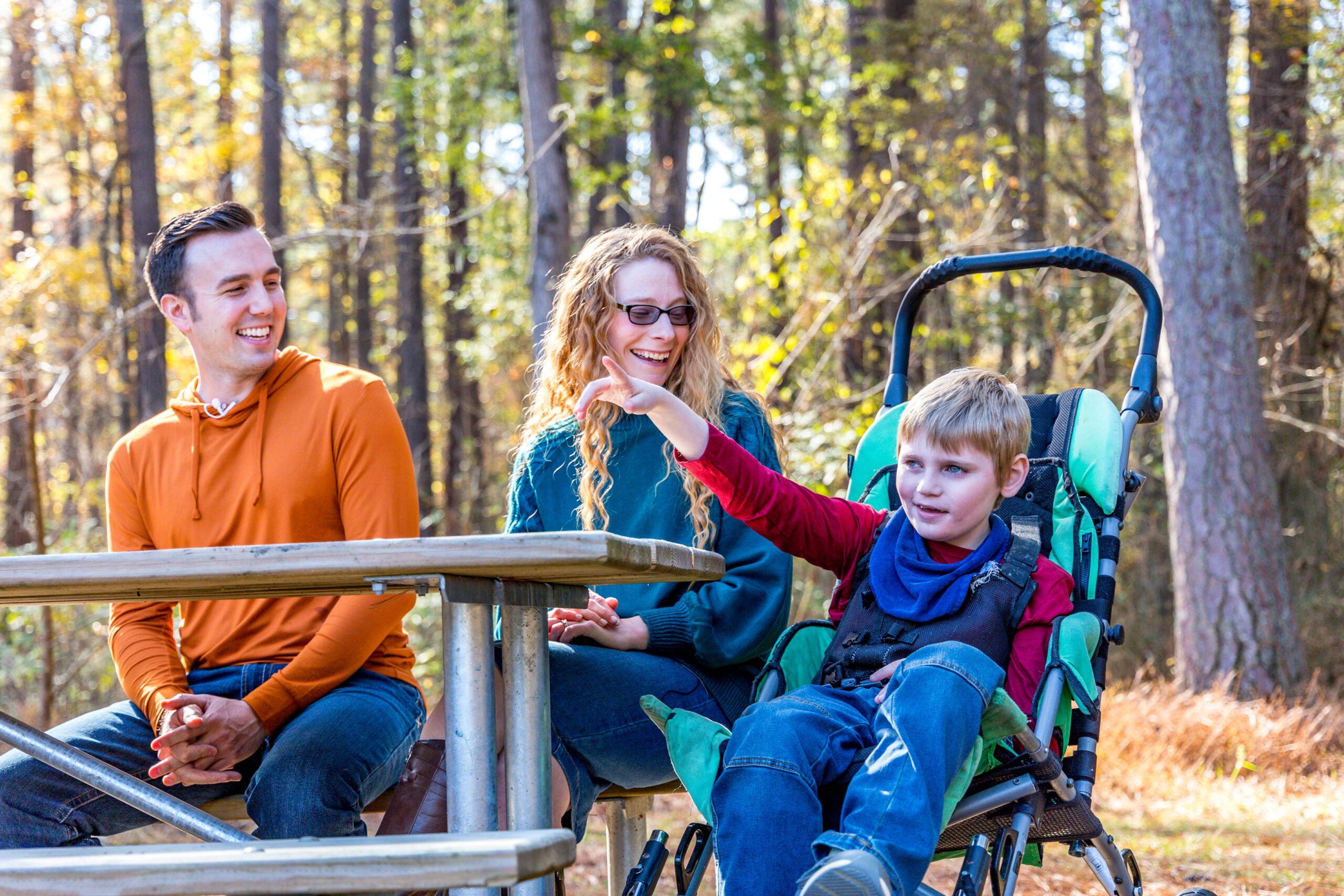 Family with a son in a wheelchair sit in a Tennessee State Park together.