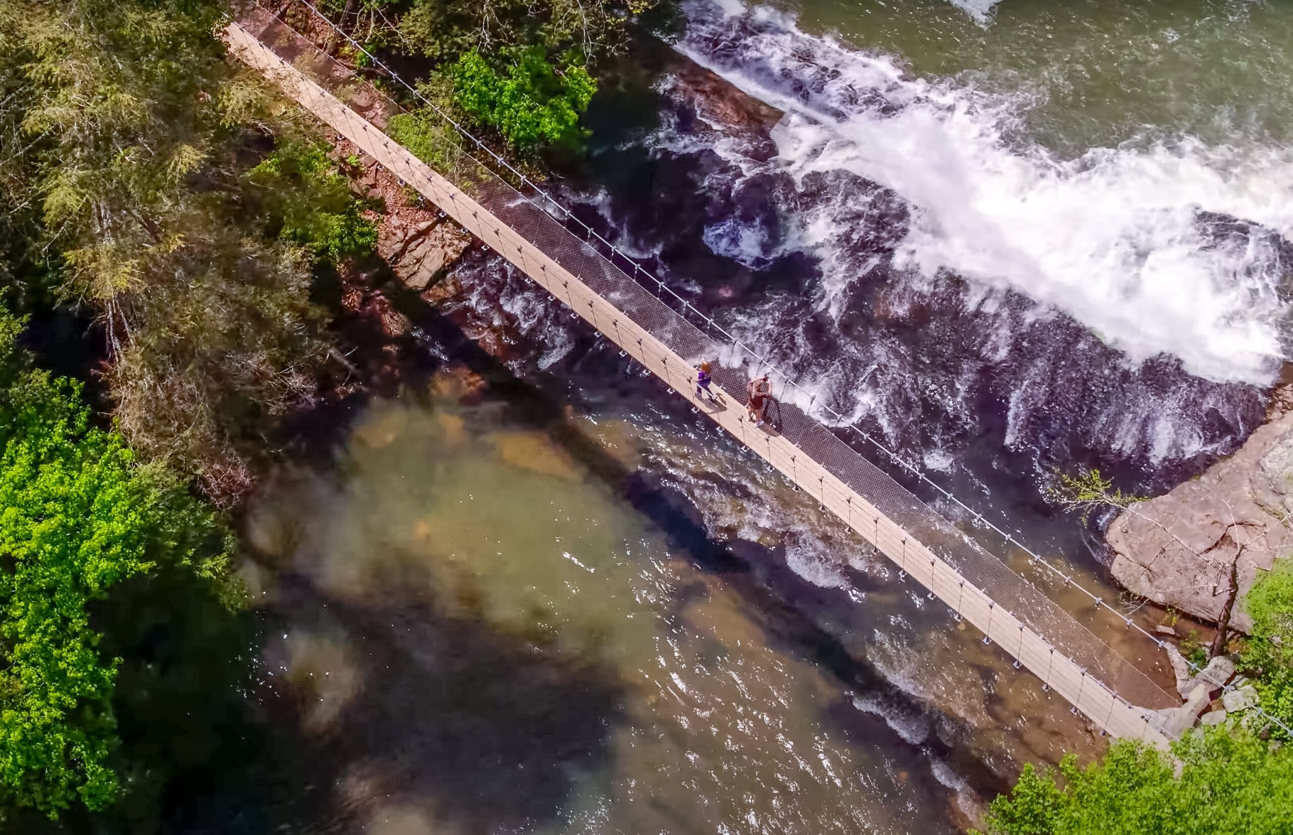 View of a park bridge near a waterfall from a drone. 